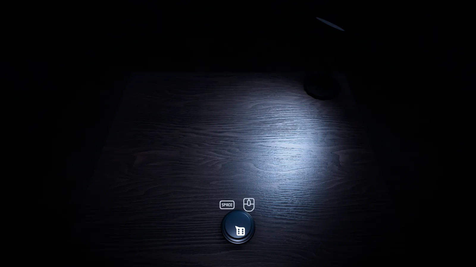 A single die and the blue button under the desk lamp
